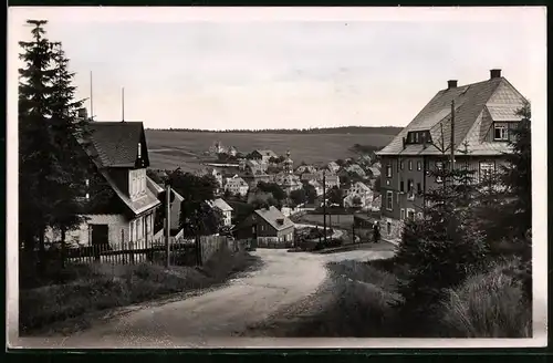 Fotografie Brück & Sohn Meissen, Ansicht Carlsfeld i. Erzg., Strassenpartie im Ort mit Blick zur Kirche