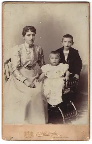 Fotografie A. Rehmke, Kiel, Preusserstrasse 5, Junge Frau in hübscher Kleidung mit zwei Kindern