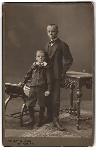 Fotografie Willy Wilcke, Hamburg, Steindamm 54-56, Halbwüchsiger Knabe im Anzug mit kleinem Jungen