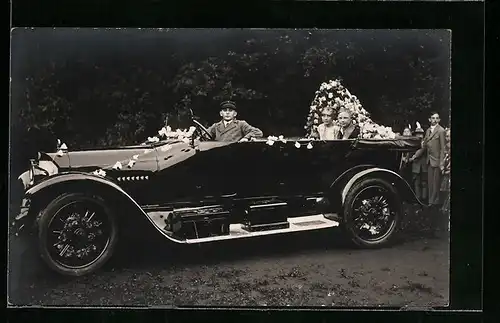 Foto-AK Junges Paar im festlich geschmückten Auto