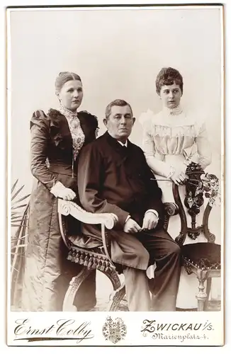 Fotografie Ernst Colby, Zwickau i. S., Marienplatz 4, Älteres Paar und junge Frau in hübscher Kleidung