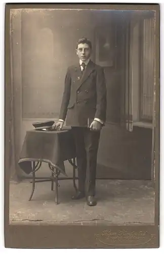 Fotografie Max Hentschel, Dresden-Löbtau, Reisewitzerstrasse 11, Student im Anzug mit Schirmmütze und Buch