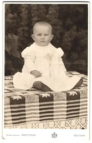 Fotografie Hoffmann, Weimar, Schröterstrasse 31, Kleinkind im Kleid sitzt auf einem Tisch