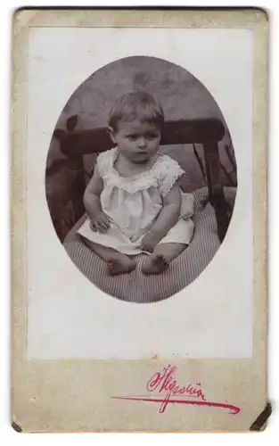 Fotografie Hegedüne, Ort unbekannt, Kleinkind im Hemd mit nackigen Füssen