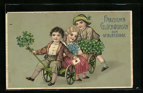 AK Glückwünsche zum Geburtstag, Kinder auf dem Bollerwagen mit Kleeblättern