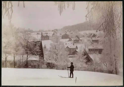 Fotografie Brück & Sohn Meissen, Ansicht Bärenfels i. Erzg., Blick aus dem Wald auf den Ort im Winter mit Skifahrer