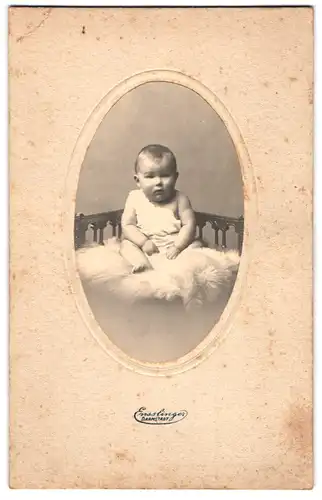 Fotografie Ensslinger, Darmstadt, Kleinkind im Hemd sitzt auf einem Fell