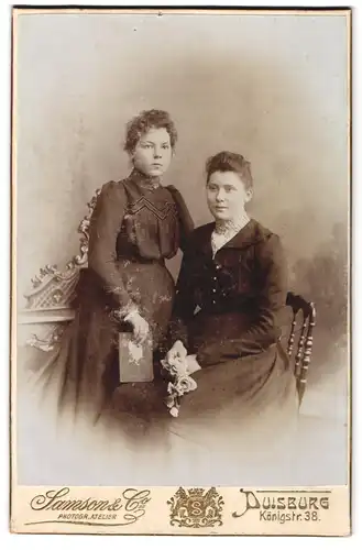 Fotografie Samson & Co., Duisburg, Königstrasse 38, Zwei junge Damen in Kleidern mit Buch