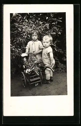Foto-AK Zwei kleine Kinder mit Puppenwagen im Garten