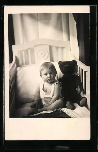 Foto-AK Kleinkind mit Teddy im Bettchen