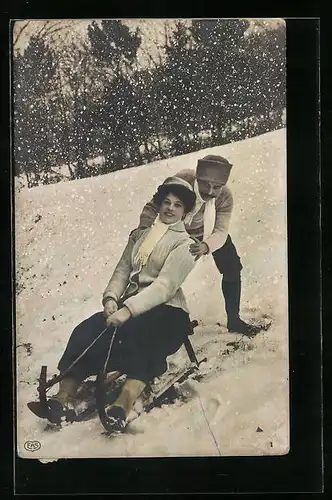 AK Mann schiebt eine Dame auf einem Schlitten an