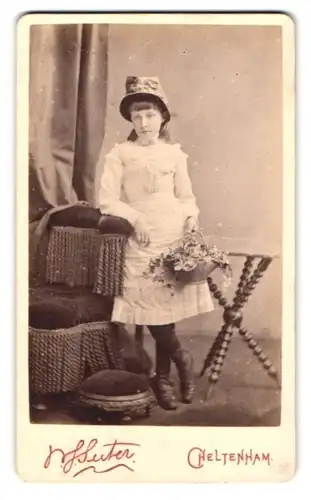 Fotografie Suter, Cheltenham, Royal House, Portrait hübsches Mädchen mit Hut und Blumenkorb