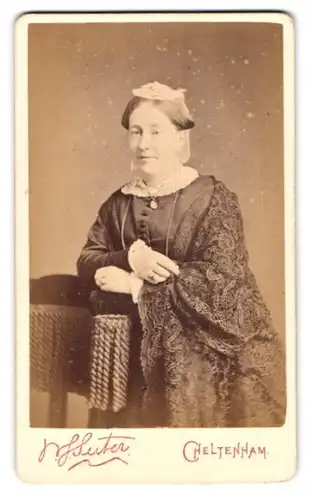 Fotografie Suter, Cheltenham, Portrait hübsche Dame mit Rüschenhaarschmuck im bestickten Kleid