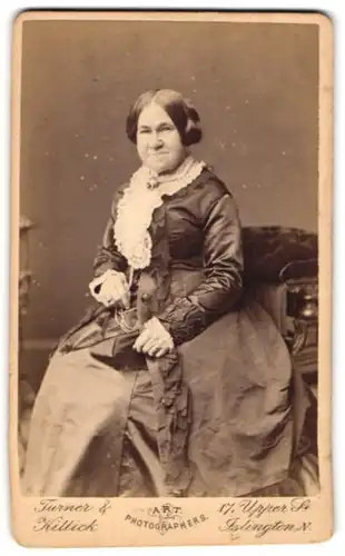 Fotografie Turner & Killick, Islington, 17, Upper St., Portrait einer elegant gekleideten Frau mit Buch in der Hand