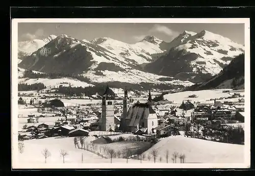 AK Kitzbühel, verschneite Ortsansicht mit Gebirgskette