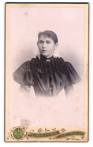 Fotografie Atelier L. Wolter, Finsterwalde, Schulstr., Junge Frau im schwarzen Kleid mit weisser Schleife im Haar