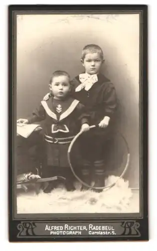 Fotografie Alfred Richer, Radebeul, Carolastrasse 5, Zwei modisch gekleidete kleine Jungen mit Reifen