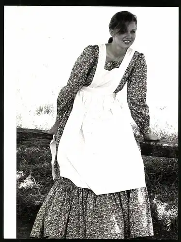 Fotografie hübsche junge Frau posiert im Sommerkleid mit Schürze im Stil eines Bauernmädchen's