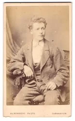 Fotografie Humphreys, Carnarvon, Castle Square, Portrait junger Mann mit lockigem Haar
