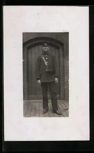 Foto-AK Briefträger in Uniform mit Schirmmütze