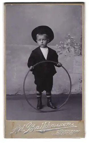 Fotografie Ad. Balkhausen, Düsseldorf, Kleiner Junge mit Reifen und Hut
