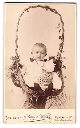 Fotografie Strom & Walter, Berlin, Köpnicker-Str. 102, Baby mit Taufkleid im Korb sitzend
