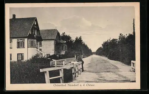 AK Niendorf a. d. Ostsee, Strassenpartie mit Brücke und Häusern