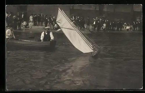 Foto-AK Bootsfahrer mit einem Modellsegelboot