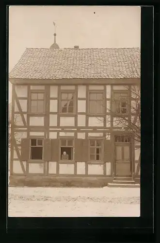 Foto-AK Altenburschla, Mann im Fenster eines Fachwerkhauses