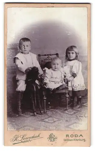 Fotografie R. Lowatsch, Roda, Sachsen-Altenburg, Bruder auf Spielzeugpferd mit Schwestern in Kleidern