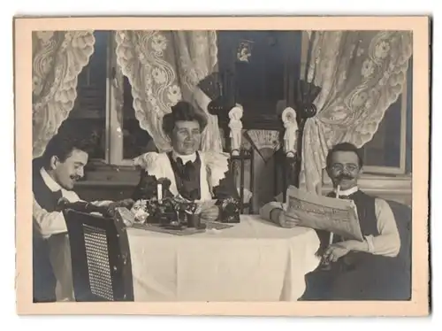 Fotografie Familie sitzt gemeinsam in der Stube beim Zeitung lesen