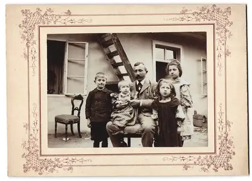 Fotografie unbekannter Fotograf und Ort, Vater mit Töchtern & Sohn im Hof sitzend