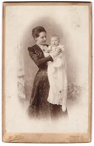 Fotografie H. Hilse, Berlin, Schönhauser Allee 49, Mutterglück, junge Mutter hält Baby im Taufkleid