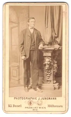 Fotografie J. Jungmann, Kl. Basel, Hammerstr. 13, Elegant gekleideter Herr lehnt am Sockel