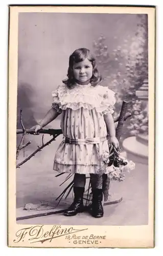 Fotografie F. Delfino, Genève, 19, Rue de Berne, Kleines Mädchen im Kleid mit Blumen