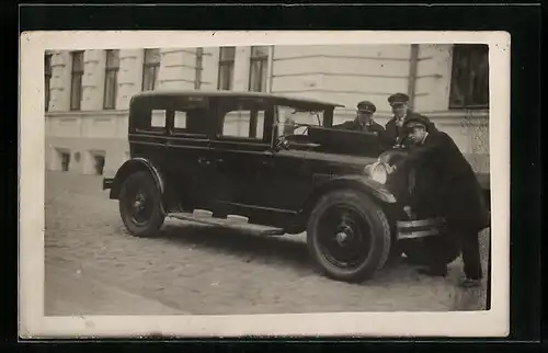 AK Männer begutachten den Motor eines Autos
