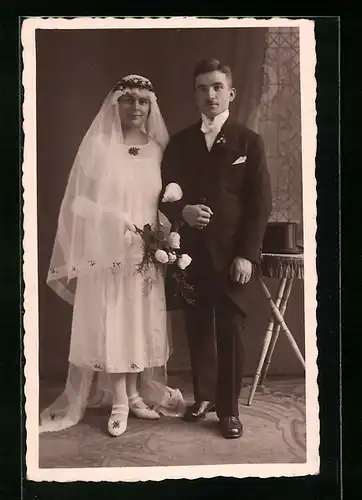 Foto-AK Glückliches junges Brautpaar, er mit Zylinder, sie mit langem Schleier