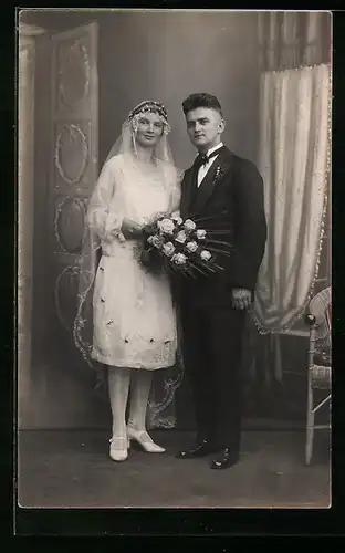 Foto-AK Junges Brautpaar im Fotostudio, sie mit Blumenstrauss