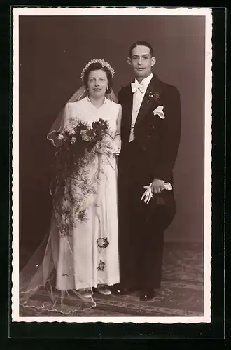 Foto-AK Junges Brautpaar im Fotostudio, sie mit Blumenstrauss, er mit Zylinderhut