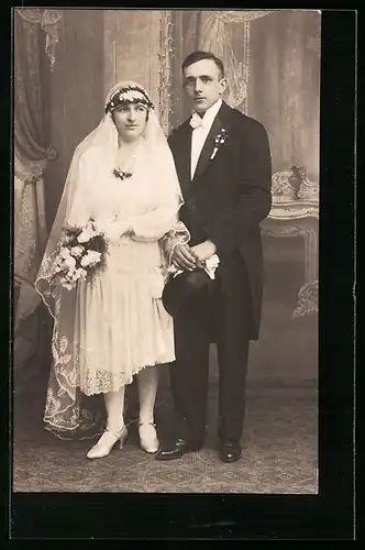 Foto-AK Junges Brautpaar im Fotostudio, sie mit Blumenstrauss, er mit Zylinderhut