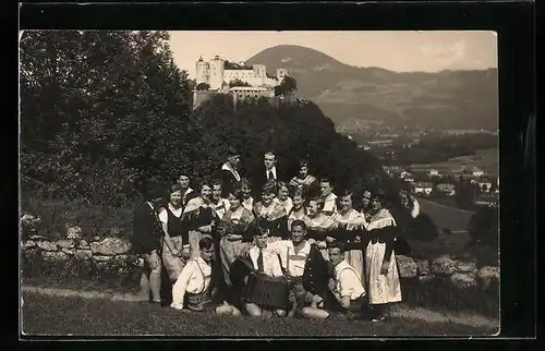 AK Salzburg, Gruppenbild in Volkstrachten, Blick zur Festung über der Stadt