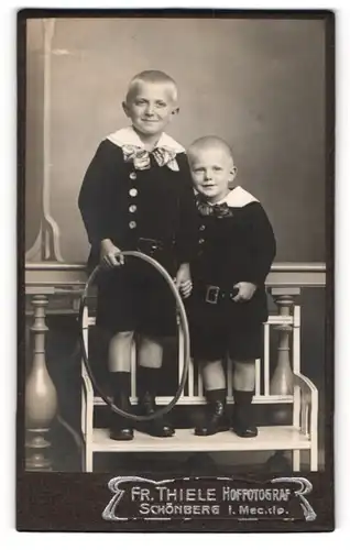 Fotografie Fr. Thiele, Schönberg i. M., Portrait zwei freche blonde Buben mit Reifen