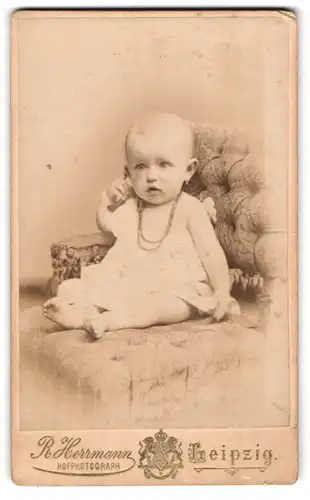 Fotografie R. Herrmann, Leipzig, Wintergartenstr. 9, Portrait süsses Kleinkind mit Halskette im weissen Hemdchen