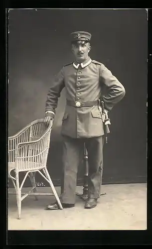 Foto-AK Soldat in Uniform am Korbstuhl, Uniformfoto