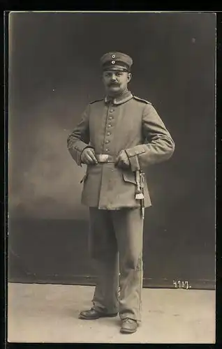 Foto-AK Soldat in Uniform mit Schirmmütze, Uniformfoto