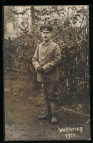 Foto-AK Soldat in Uniform mit Schirmmütze und Degen, Weltkrieg 1914, Uniformfoto