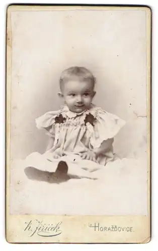 Fotografie K. Jiricek, Horazdovice, Portrait blondes Kleinkind im niedlichen weissen Kleidchen