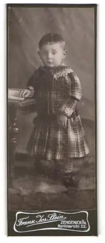 Fotografie Franz Jos. Stein, Zehdenick i. M., Berlinerstr. 22, Niedliches Kleinkind im karierten Kleid