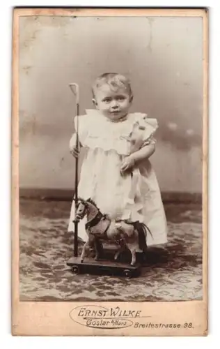 Fotografie Ernst Wilke, Goslar / Harz, Breitestr. 98, kleines Mädchen im weissen Kleid mit Spielzeug-Pferd
