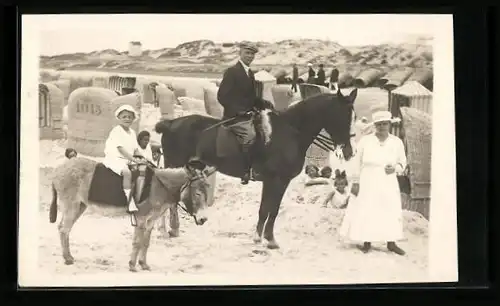 Foto-AK Familie mit auf Esel reitendem Knaben am Strand